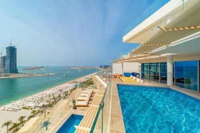 a hotel with a swimming pool and a beach at EDEN'S Homes & Villas - FIVE Palm Residences Penthouses in Dubai