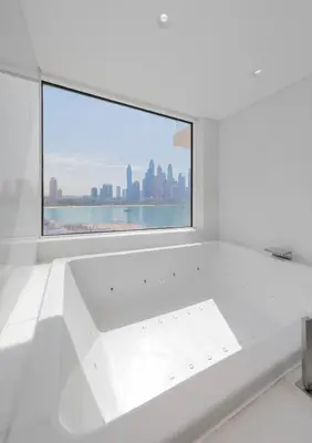 a white room with a window with a view of the city at EDEN'S Homes & Villas - FIVE Palm Residences Penthouses in Dubai