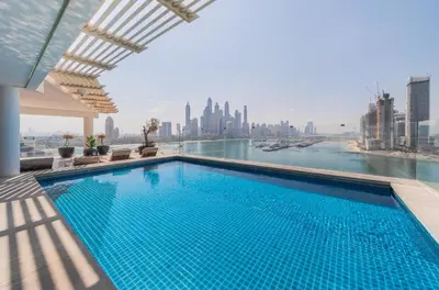 a large swimming pool with a view of the city at EDEN'S Homes & Villas - FIVE Palm Residences Penthouses in Dubai