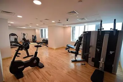 a gym with treadmills and exercise bikes in a room at Nice Studio in JVC - Pool & Gym in Dubai