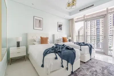 two beds in a bedroom with a large window at GuestReady - Fabulous 2BR with Burj Khalifa view in Dubai
