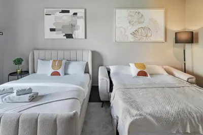 two beds in a small room with white walls at Luxury studio in Discovery Gardens near metro in Dubai