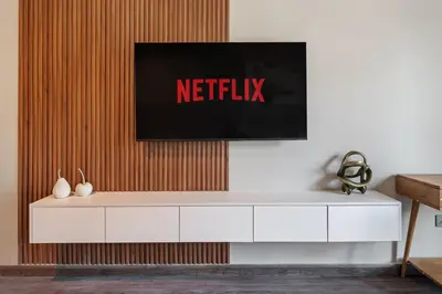a white cabinet with a netflix sign on a wall at Luxury studio in Discovery Gardens near metro in Dubai