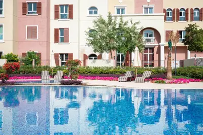 a swimming pool with chairs and a building at Luxury studio in Discovery Gardens near metro in Dubai