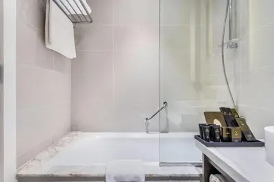 a bathroom with a shower and a bath tub at The S Holiday Homes Canal view Studio and One Bedroom Apartments, Damac Maison Prive in Dubai