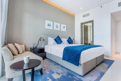 a bedroom with a bed and a couch and a table at The S Holiday Homes Canal view Studio and One Bedroom Apartments, Damac Maison Prive in Dubai