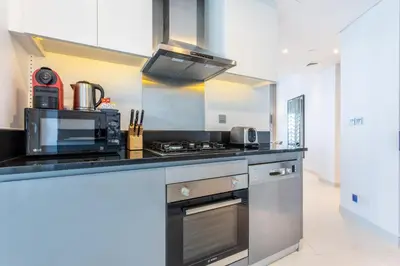 a kitchen with a stove and a microwave at The S Holiday Homes Canal view Studio and One Bedroom Apartments, Damac Maison Prive in Dubai