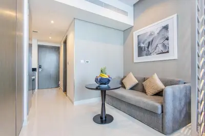 a living room with a couch and a table at The S Holiday Homes Canal view Studio and One Bedroom Apartments, Damac Maison Prive in Dubai