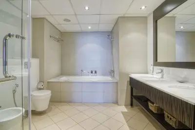 a bathroom with a tub and a toilet and a sink at Marvelous private beach apartment in Palm Dubai within Anantara 5 star resort in Dubai