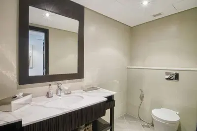 a bathroom with a sink and a toilet and a mirror at Marvelous private beach apartment in Palm Dubai within Anantara 5 star resort in Dubai
