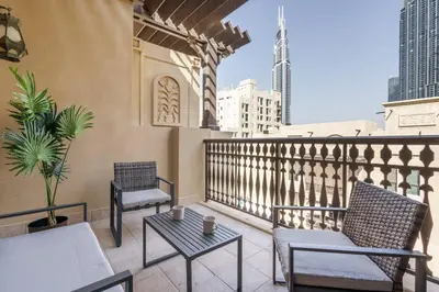 a balcony with two chairs and a table on a balcony at GuestReady - Luxe Arabian Apartment in Downtown in Dubai