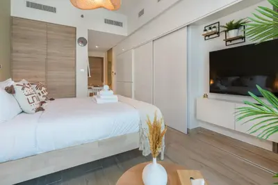 a bedroom with a large bed and a flat screen tv at Stunning Apt Marina view with Balcony in Dubai