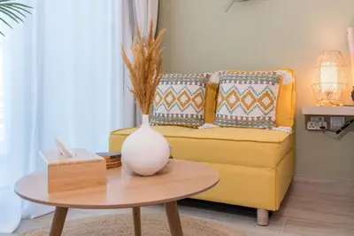a living room with a yellow couch and a table at Stunning Apt Marina view with Balcony in Dubai