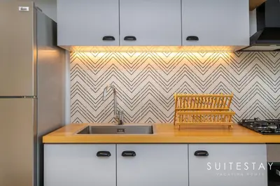 a kitchen with a sink and a counter top at Chic One Bedroom Suite with Cozy Interiors in Dubai
