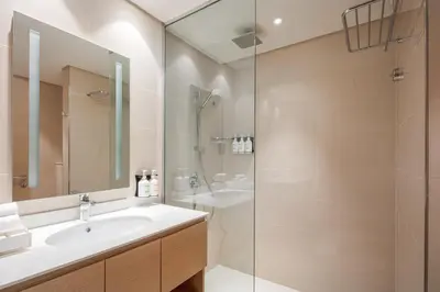a bathroom with a sink and a shower at Holiday Inn & Suites - Dubai Science Park by IHG in Dubai