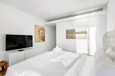 a white bedroom with a flat screen tv and a bed at Phenomenal 2BR with Scenic Sea-View from ALL rooms! in Dubai