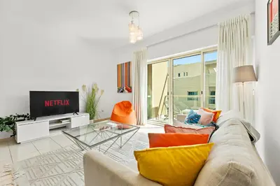 a living room with a couch and a tv at Charming 1BR in The Greens, Near Metro in Dubai