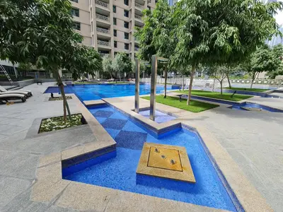 a swimming pool with a blue floor and trees at Marco Polo - Wake up to breathtaking Burj Khalifa views in Dubai