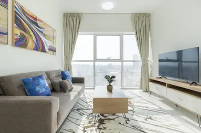 a living room with a couch and a tv at Tranquil 1BR apartment in Carson C, Damac Hills - Allsopp&Allsopp in Dubai