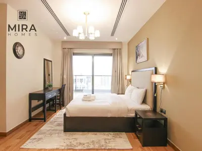 a bedroom with a bed and a desk and a window at Mira Holiday Homes - Lovely 1 bedroom in Downtown in Dubai