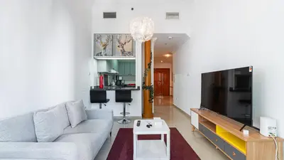 a living room with a couch and a tv at Cosy 1 Bedroom Marina Apartment in Dubai
