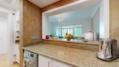 a kitchen with a washer and dryer and a mirror at Elegant 2 BR Apartment with Beach Access in Dubai