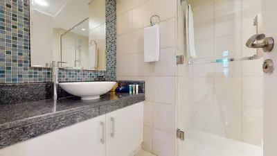a bathroom with a sink and a shower at Elegant 2 BR Apartment with Beach Access in Dubai