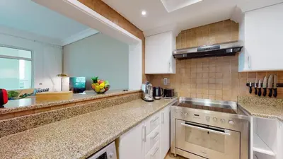 a kitchen with white cabinets and a stove top oven at Elegant 2 BR Apartment with Beach Access in Dubai
