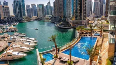 a view of a river with boats in a city at White Sage - Fendi Apartment With Full Palm Jumeirah View in Dubai