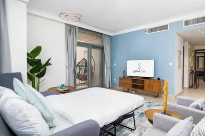 a living room with a bed and a tv at Ultimate Stay / 7 people / Spacious / Dubai Creek with Marina Views in Dubai