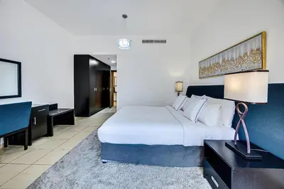 a hotel room with a large bed and a desk at Comfy 1BD family apartment in Shams JBR in Dubai