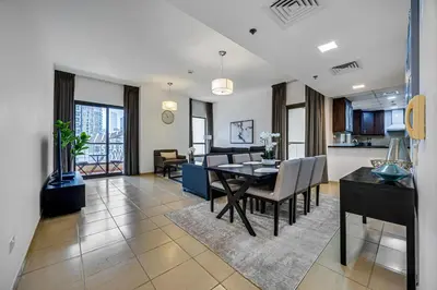 a dining room and living room with a dining table at Comfy 1BD family apartment in Shams JBR in Dubai