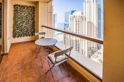 a balcony with a table and chairs in a building at Cozy 2 BD in Bahar JBR 24 floor in Dubai