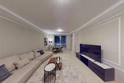 a living room with a couch and a large flat screen tv at Palmar One Bedroom with Private Beach! in Dubai