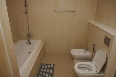 a bathroom with a toilet and a tub and a sink at Palmar One Bedroom with Private Beach! in Dubai