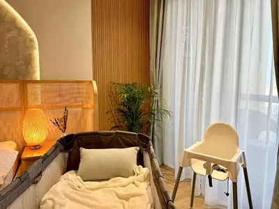 a bedroom with a bed and a table and a chair at Family apartment next to the beach in Dubai