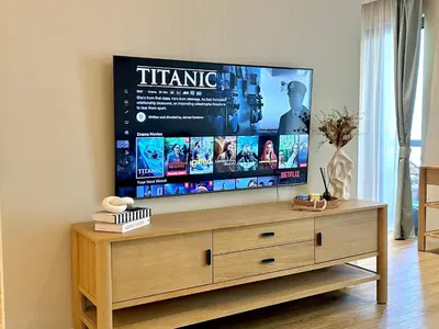 a flat screen tv sitting on top of a wooden entertainment center at Family apartment next to the beach in Dubai