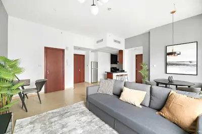 a living room with a couch and a dining room at Silkhaus just furnished 1BDR in JBR near the beach in Dubai