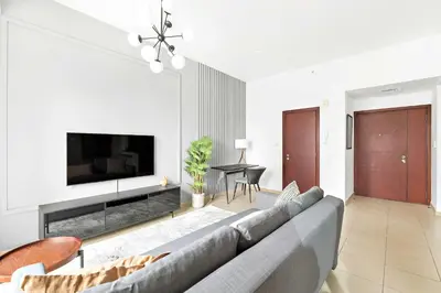 a living room with a couch and a flat screen tv at Silkhaus just furnished 1BDR in JBR near the beach in Dubai