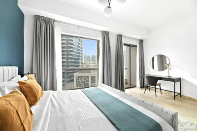 a bedroom with a bed and a desk and a window at Silkhaus just furnished 1BDR in JBR near the beach in Dubai
