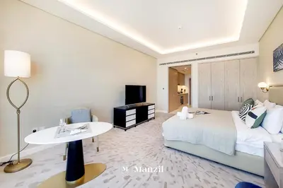a hotel room with a bed and a table at Manzil - Studio Apartment with Aura Pool & Sea View at The Palm Tower in Palm Jumeirah in Dubai