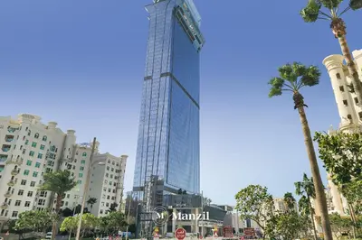 a tall building in a city with palm trees at Manzil - Studio Apartment with Aura Pool & Sea View at The Palm Tower in Palm Jumeirah in Dubai
