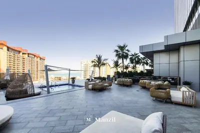 a patio with couches and chairs on a building at Manzil - Studio Apartment with Aura Pool & Sea View at The Palm Tower in Palm Jumeirah in Dubai