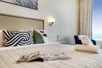 a bedroom with a large bed with a magazine on it at Manzil - Studio Apartment with Aura Pool & Sea View at The Palm Tower in Palm Jumeirah in Dubai