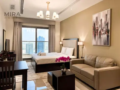 a hotel room with a bed and a couch at Mira Holiday Homes - Serviced apartment in Downtown in Dubai