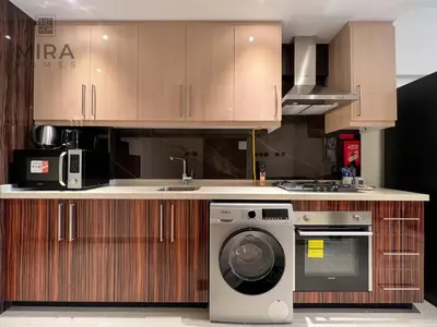 a kitchen with a washing machine and a sink at Mira Holiday Homes - Serviced apartment in Downtown in Dubai