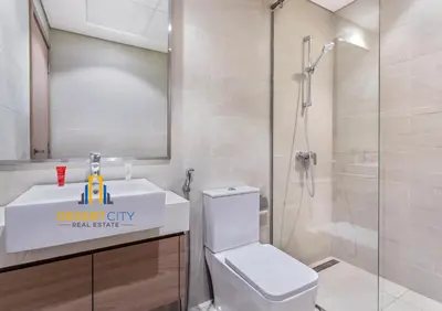 a bathroom with a shower and a toilet and a sink at 2 Bed in Azzizi Farhad with Burj Khalifa view by Desert City Stays in Dubai