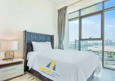 a bedroom with a white bed and a window at 2 Bed in Azzizi Farhad with Burj Khalifa view by Desert City Stays in Dubai