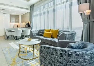 a living room with a couch and a table at 2 Bed in Azzizi Farhad with Burj Khalifa view by Desert City Stays in Dubai