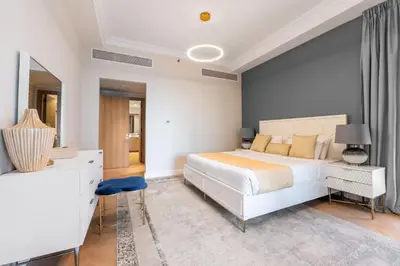 a bedroom with a large white bed and a desk at Ultra Luxury Palm - Free 5-star Beach Resorts Access in Dubai